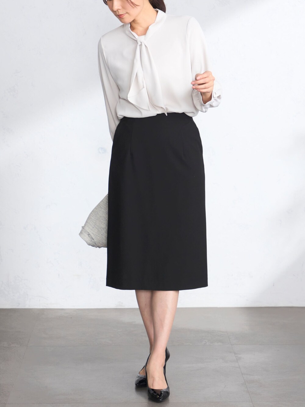 グレー系のシャツ/ブラウス、ブラック系のスカート、グレー系のその他アウターを着用したレディースの冬コーディネートの3枚目の写真