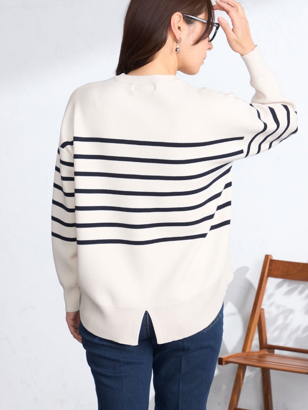 ベージュ系のステンカラーコート、ブルー系のニット/セーターを着用したレディースの春コーディネートの5枚目の写真