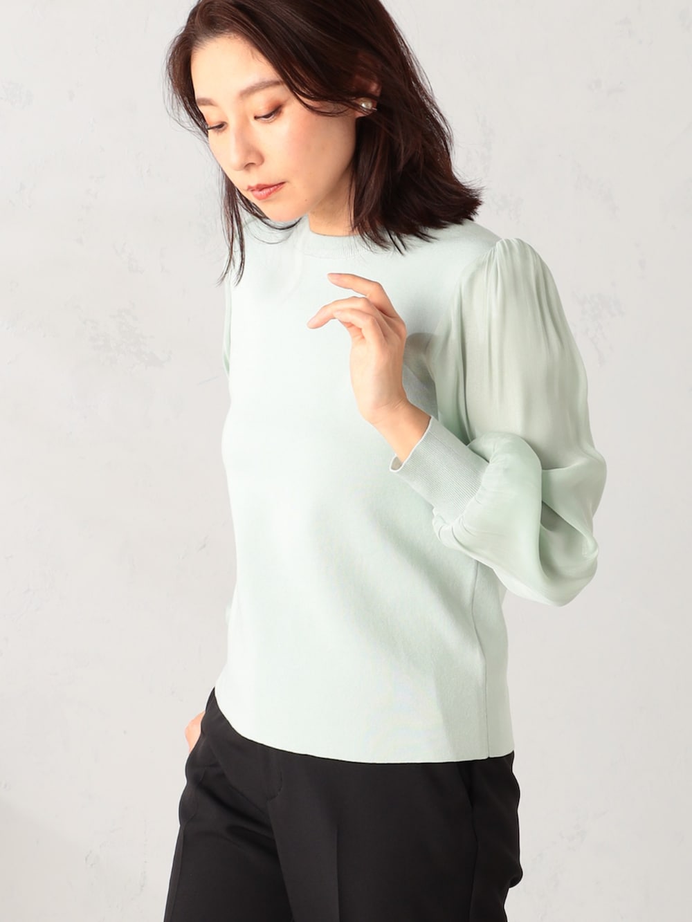 ブラック系のその他パンツ、グリーン系のニット/セーターを着用したレディースの冬コーディネートの3枚目の写真