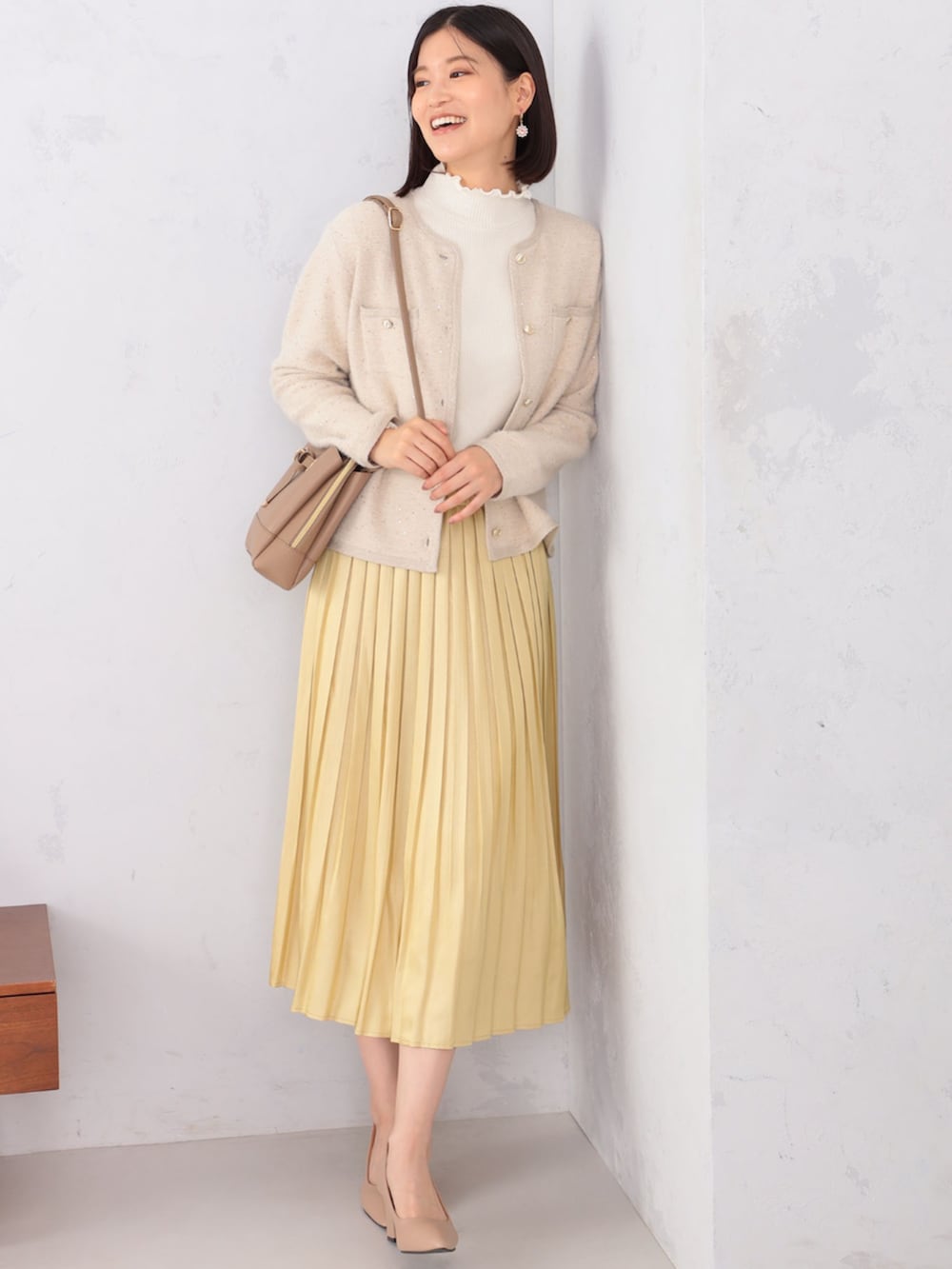 ベージュ系のカーディガン/ボレロ、ベージュ系のスカート、ベージュ系のTシャツ/カットソーを着用したレディースの冬コーディネートの2枚目の写真