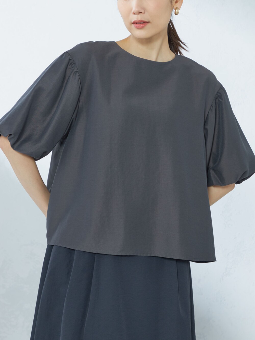 ブルー系のスカート、グレー系のシャツ/ブラウスを着用したレディースの夏コーディネートの2枚目の写真