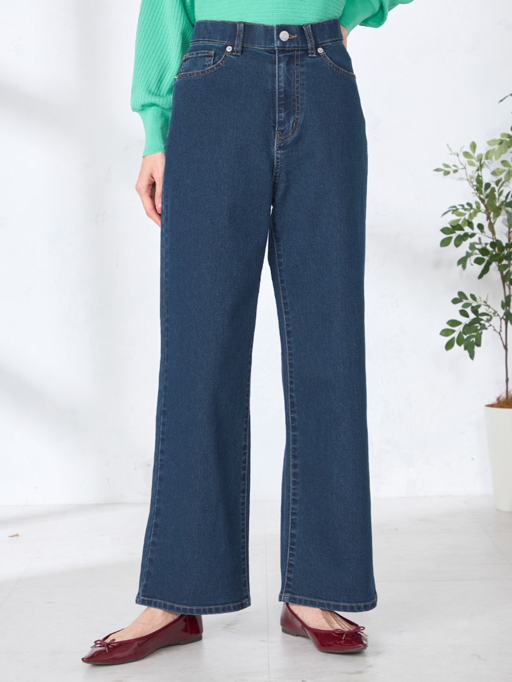 ブルー系のデニムパンツ、グリーン系のニット/セーターを着用したレディースの春コーディネートの3枚目の写真