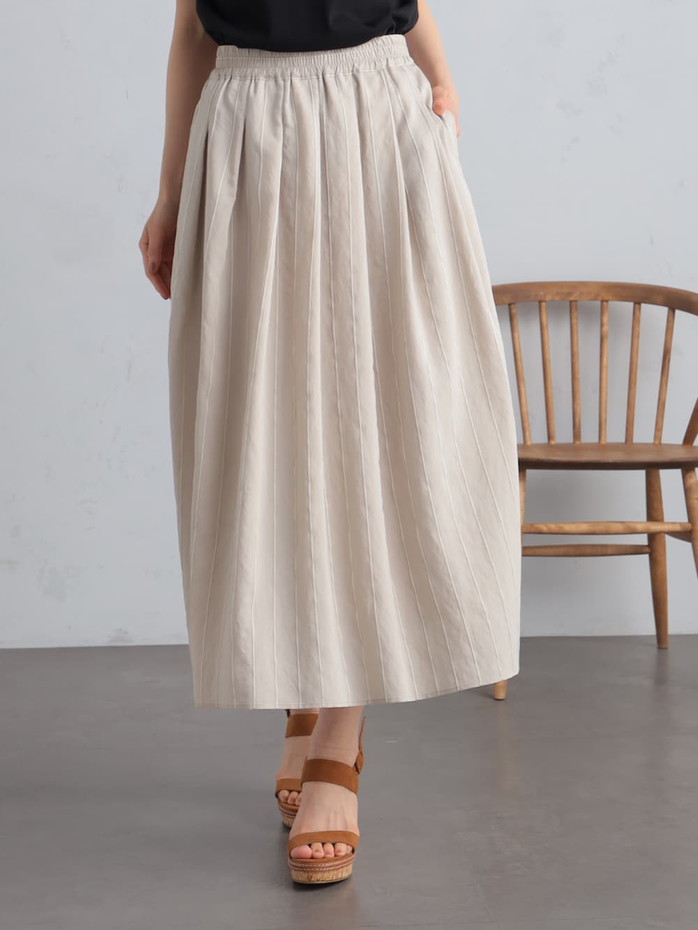 ブラック系のTシャツ/カットソー、ベージュ系のスカート、ベージュ系のパーカーを着用したレディースの夏コーディネートの5枚目の写真