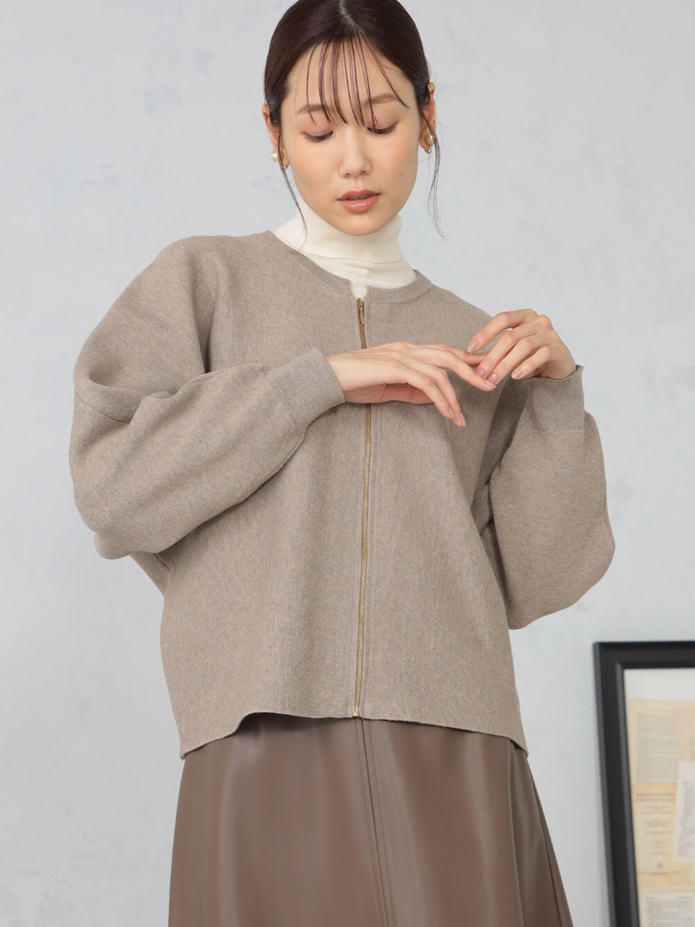 ホワイト系のニット/セーター、ブラウン系のカーディガン/ボレロ、ブラウン系のスカートを着用したレディースの秋コーディネートの2枚目の写真