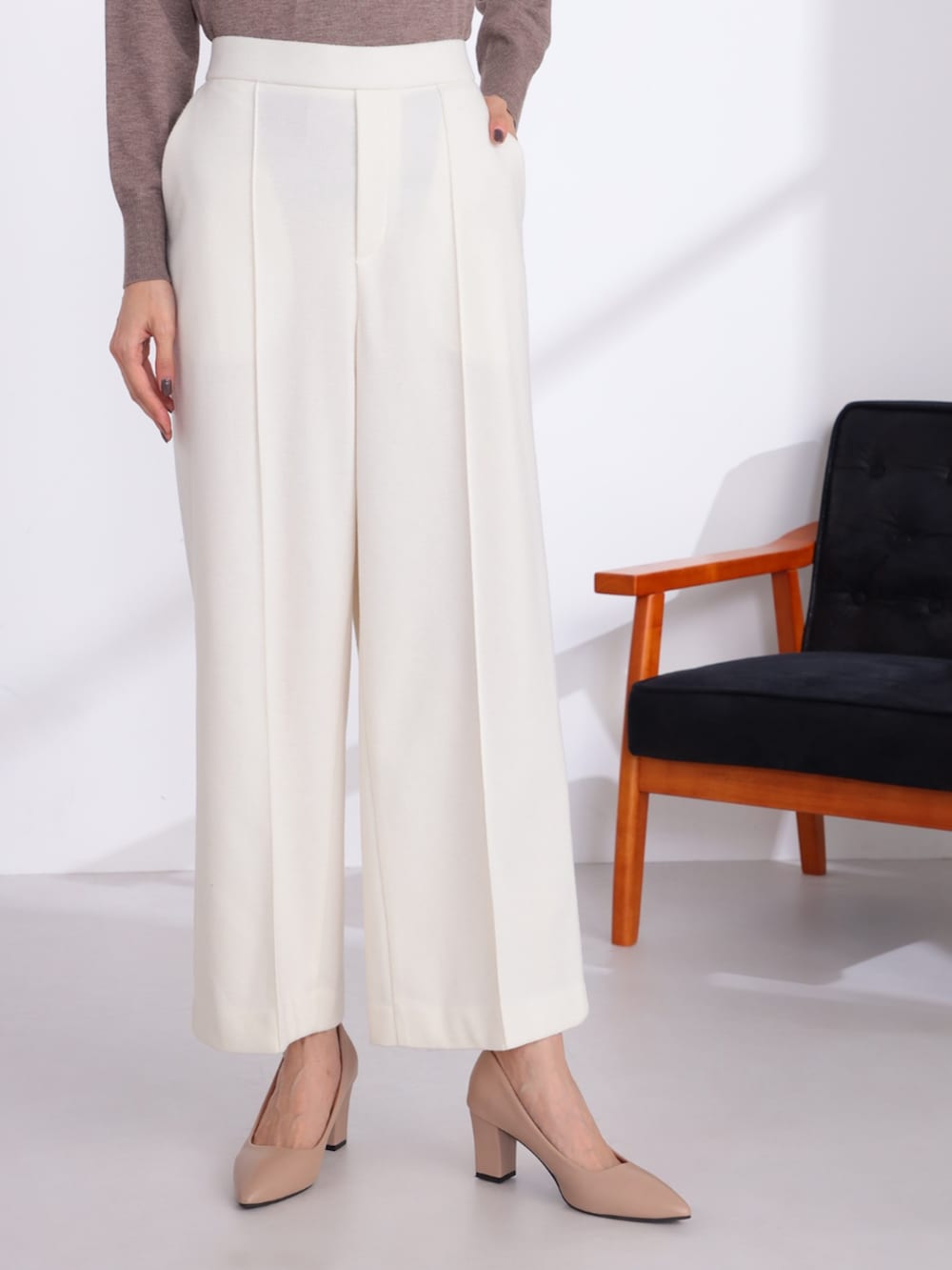 ブラウン系のニット/セーター、ベージュ系のその他パンツを着用したレディースの冬コーディネートの3枚目の写真