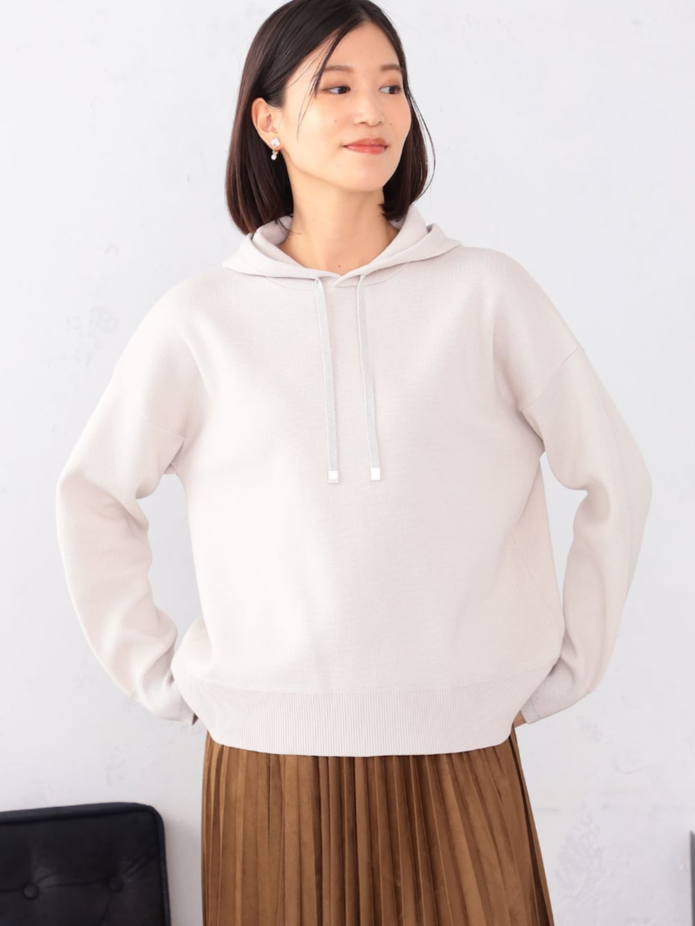 ブラウン系のスカート、グレー系のニット/セーターを着用したレディースの秋コーディネートの2枚目の写真