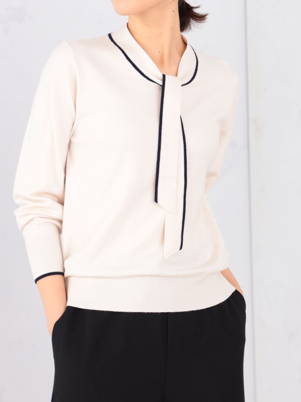 ブラック系のその他パンツ、ベージュ系のニット/セーターを着用したレディースの冬コーディネートの2枚目の写真