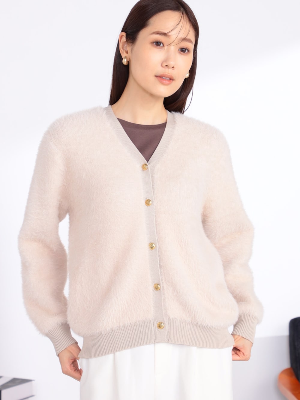 ベージュ系のアンサンブル、ホワイト系のその他パンツを着用したレディースの秋コーディネートの2枚目の写真