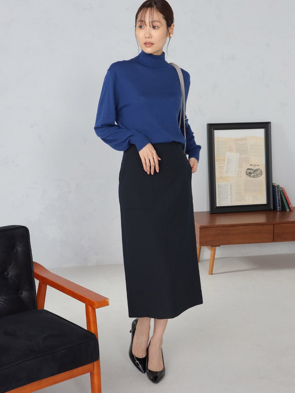 グレー系のテーラードジャケット、ブルー系のスカート、ブルー系のニット/セーターを着用したレディースの秋コーディネートの3枚目の写真