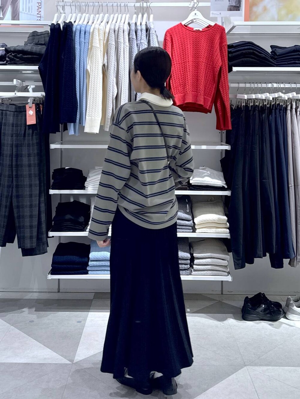 ブラック系のローファー、ブラック系のスカート、ブラック系のハンドバッグを着用したレディースの冬コーディネートの5枚目の写真