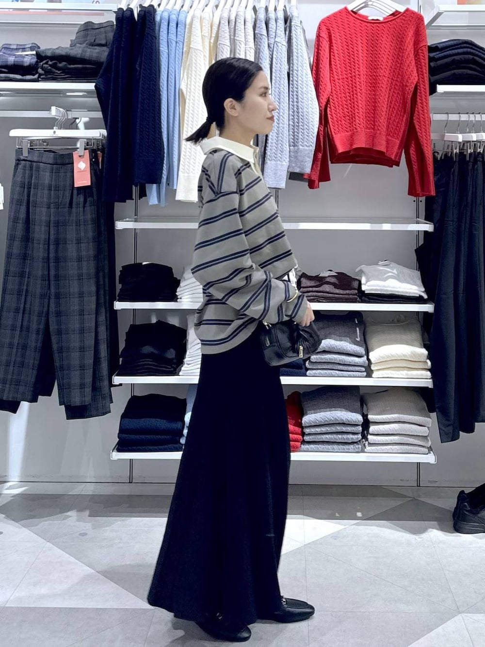 ブラック系のローファー、ブラック系のスカート、ブラック系のハンドバッグを着用したレディースの冬コーディネートの3枚目の写真