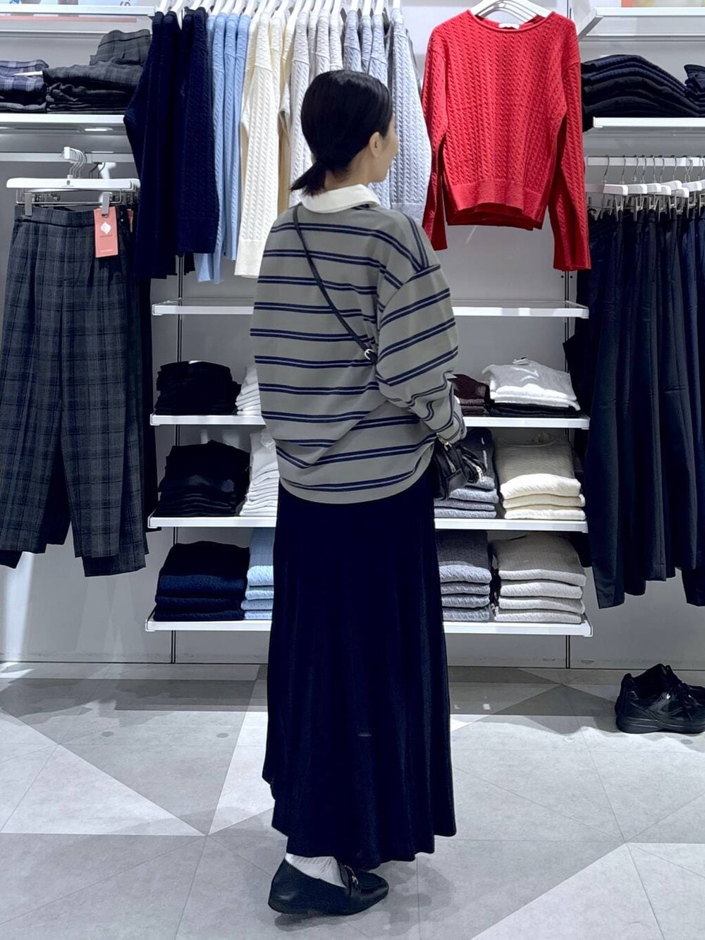 ブラック系のローファー、ブラック系のスカート、ブラック系のハンドバッグを着用したレディースの冬コーディネートの4枚目の写真