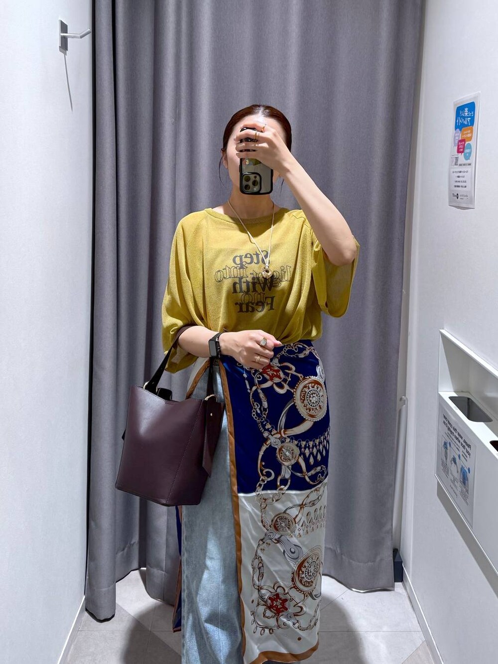 ブラウン系のショルダーバッグ、グリーン系のニット/セーター、ブルー系のデニムパンツを着用したレディースの夏コーディネートの3枚目の写真