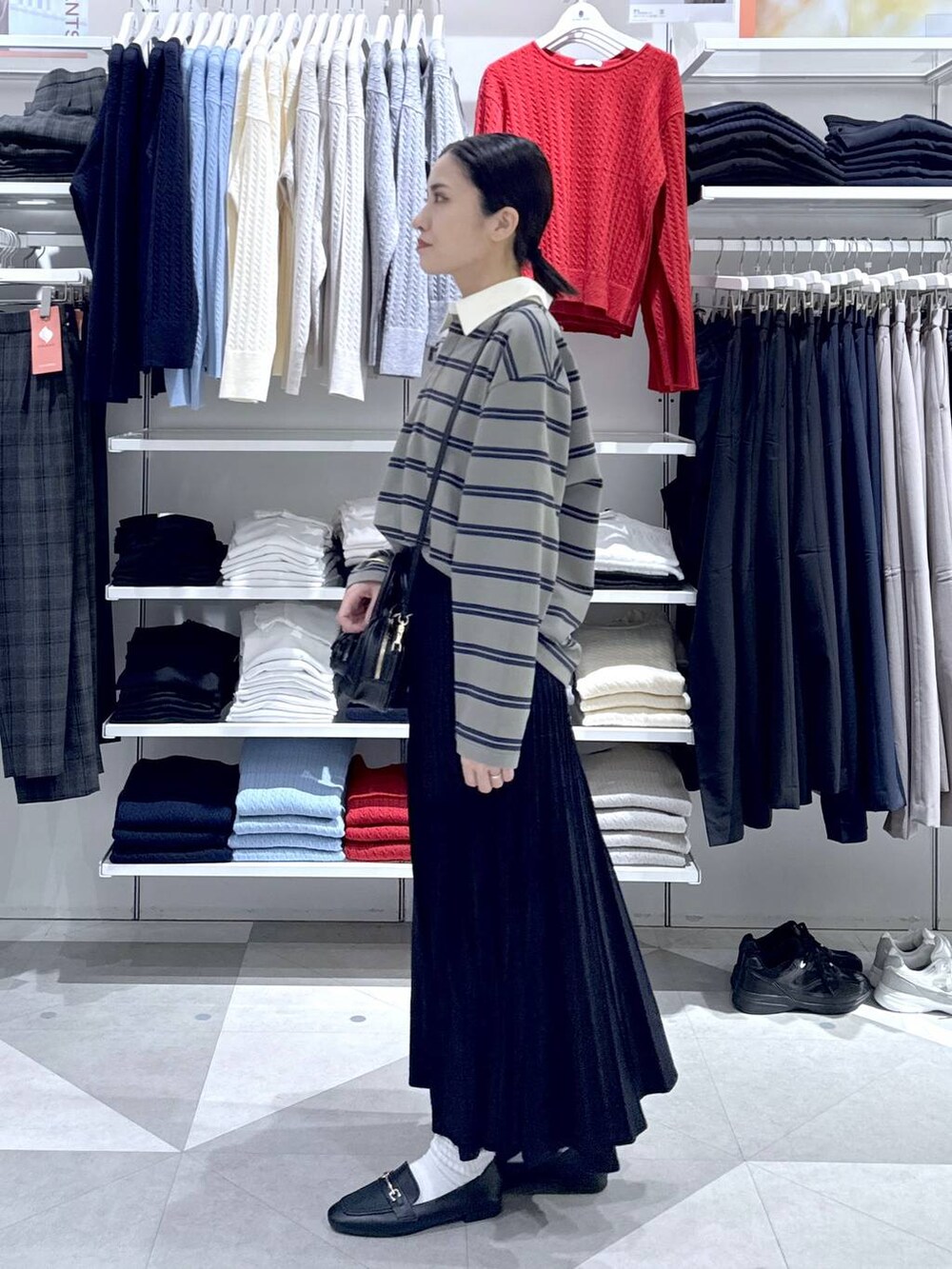 ブラック系のローファー、ブラック系のスカート、ブラック系のハンドバッグを着用したレディースの冬コーディネートの6枚目の写真