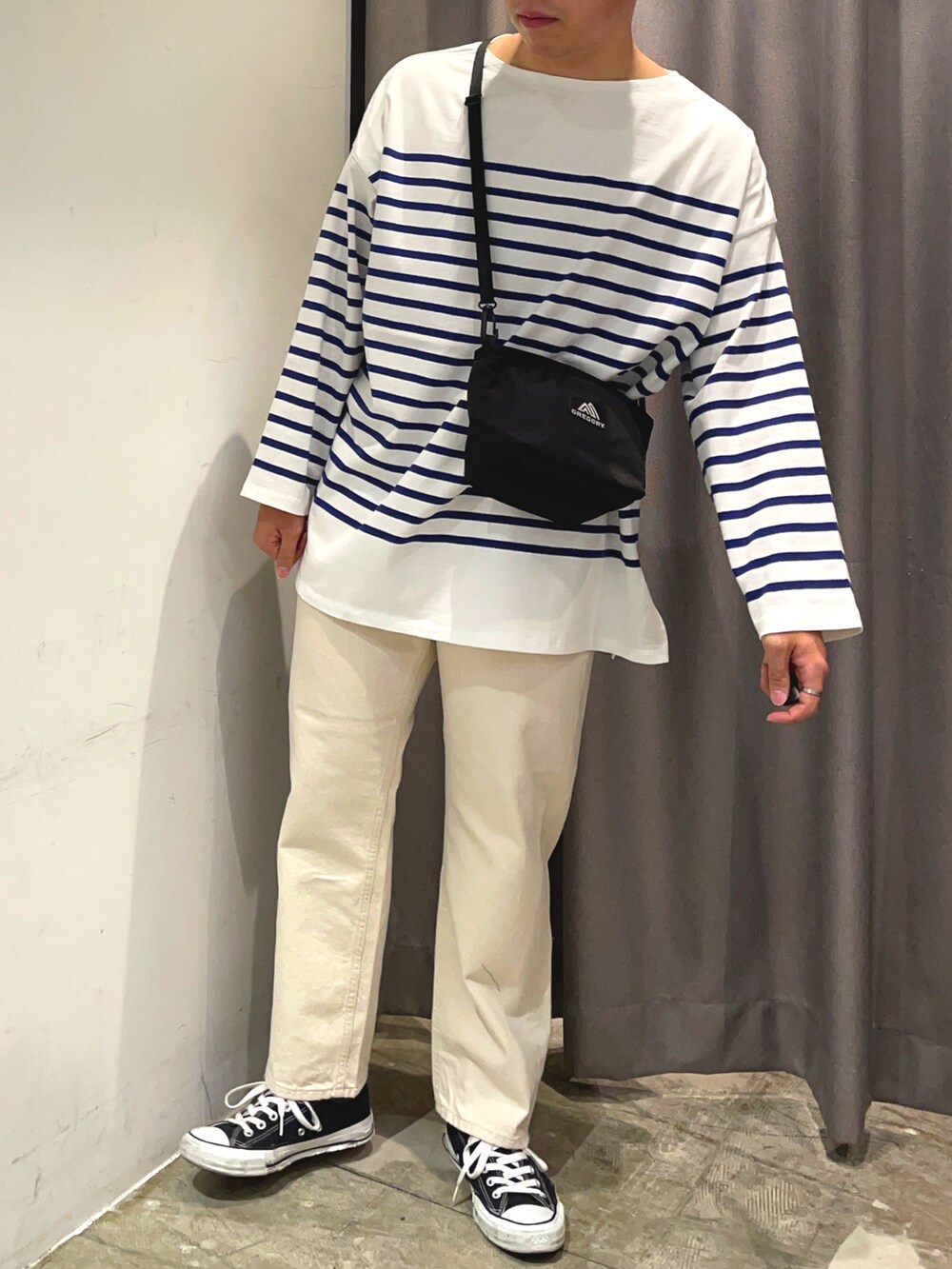 ホワイト系のデニムパンツ、ブルー系のTシャツ/カットソー、ブラック系のショルダーバッグを着用したメンズの春コーディネートの2枚目の写真