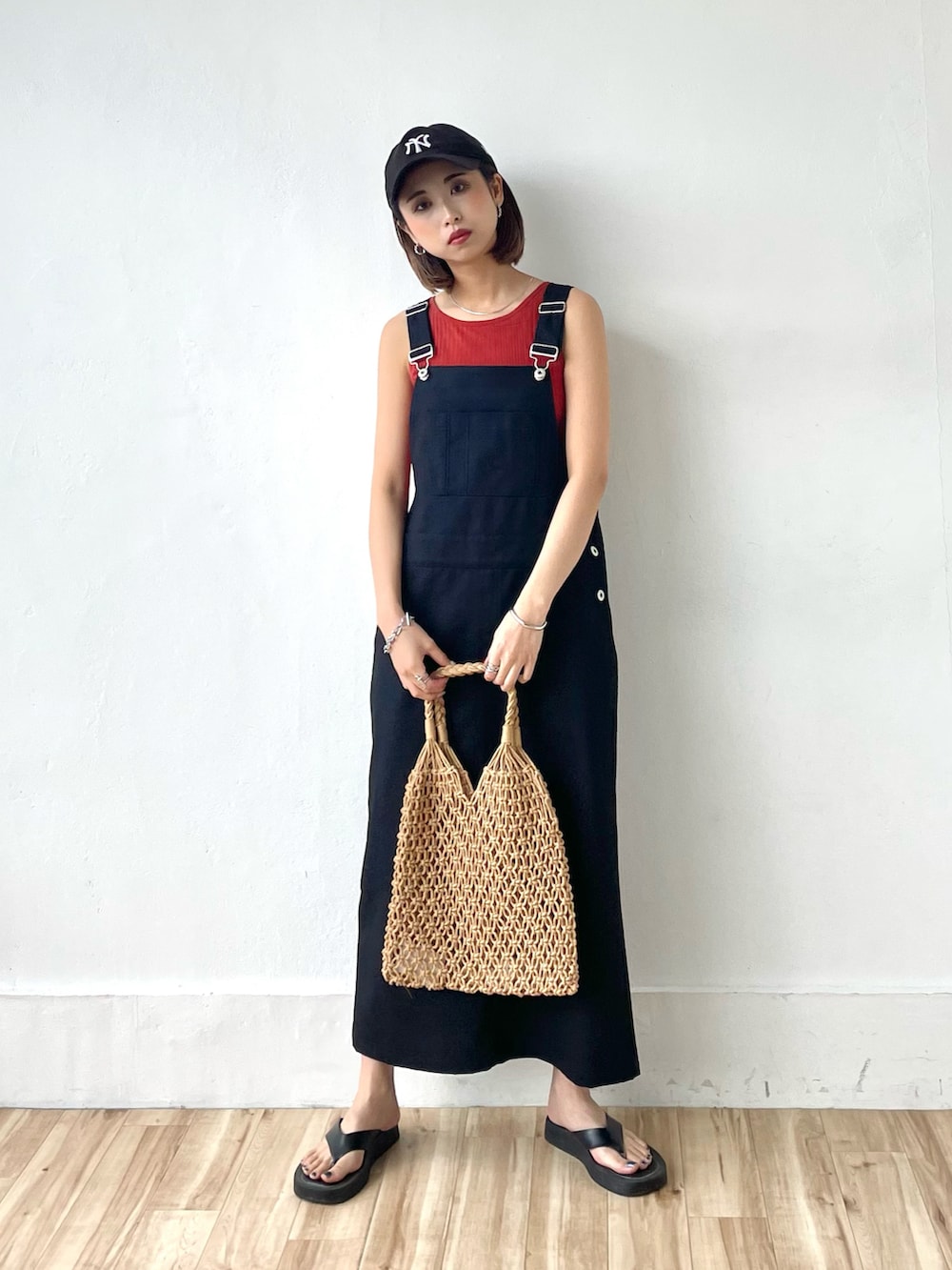 ブラック系のサロペット/オーバーオール、ブラック系のキャップ、シルバー系のバングル/リストバンドを着用したレディースの春コーディネートの2枚目の写真