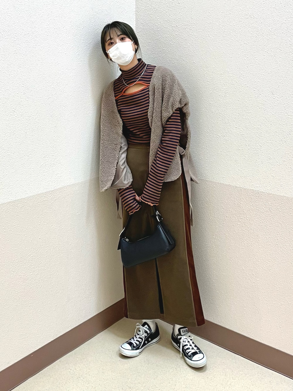 ブラウン系のTシャツ/カットソー、ブラウン系のスカート、ブラック系のショルダーバッグを着用したレディースの秋コーディネートの3枚目の写真