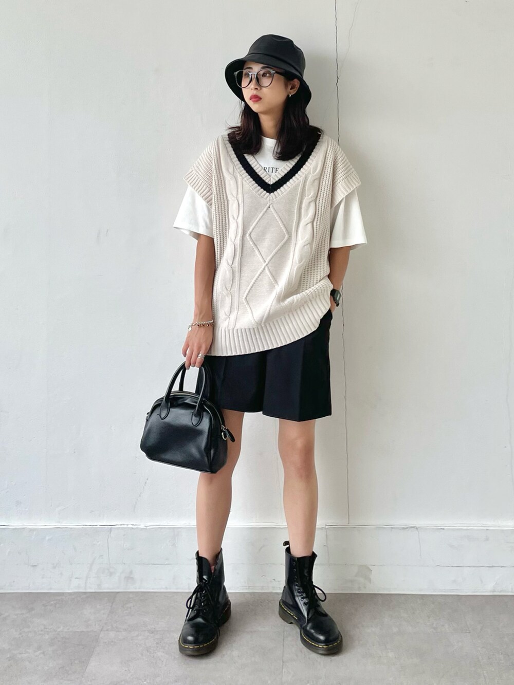 ブラック系のその他パンツ、ブラック系のブーツ、ホワイト系のTシャツ/カットソーを着用したレディースの夏コーディネートの2枚目の写真