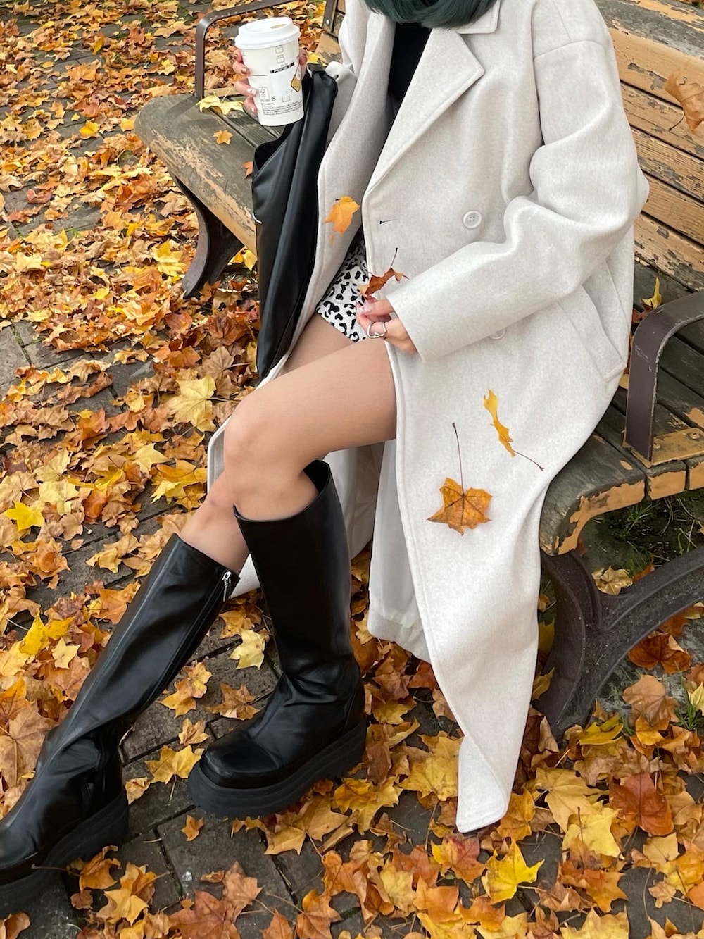 ホワイト系のチェスターコート、その他のスラックス、ブラック系のブーツを着用したレディースの秋コーディネートの3枚目の写真