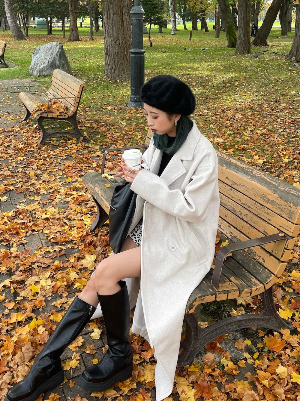 ホワイト系のチェスターコート、その他のスラックス、ブラック系のブーツを着用したレディースの秋コーディネートの2枚目の写真