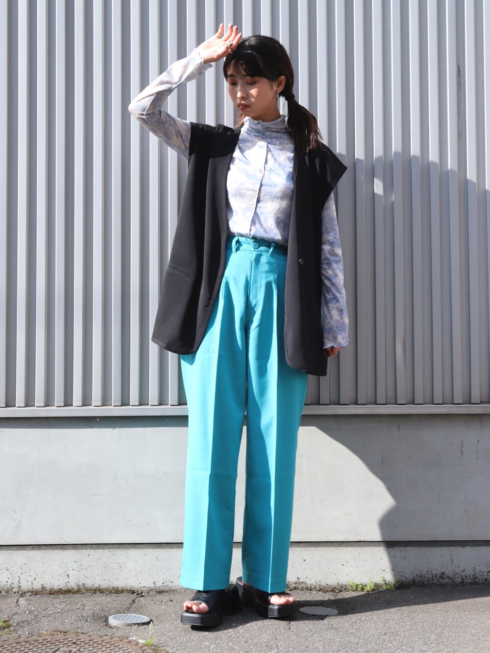 ブルー系のスラックス、ブルー系のTシャツ/カットソー、ブラック系のベストを着用したレディースの夏コーディネートの2枚目の写真