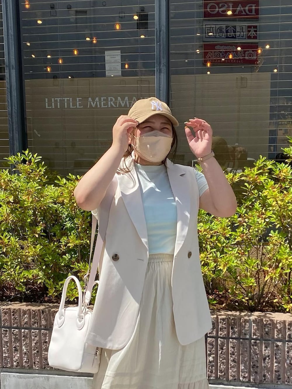 ホワイト系のベスト、グリーン系のTシャツ/カットソー、ベージュ系のスカートを着用したレディースの夏コーディネートの3枚目の写真