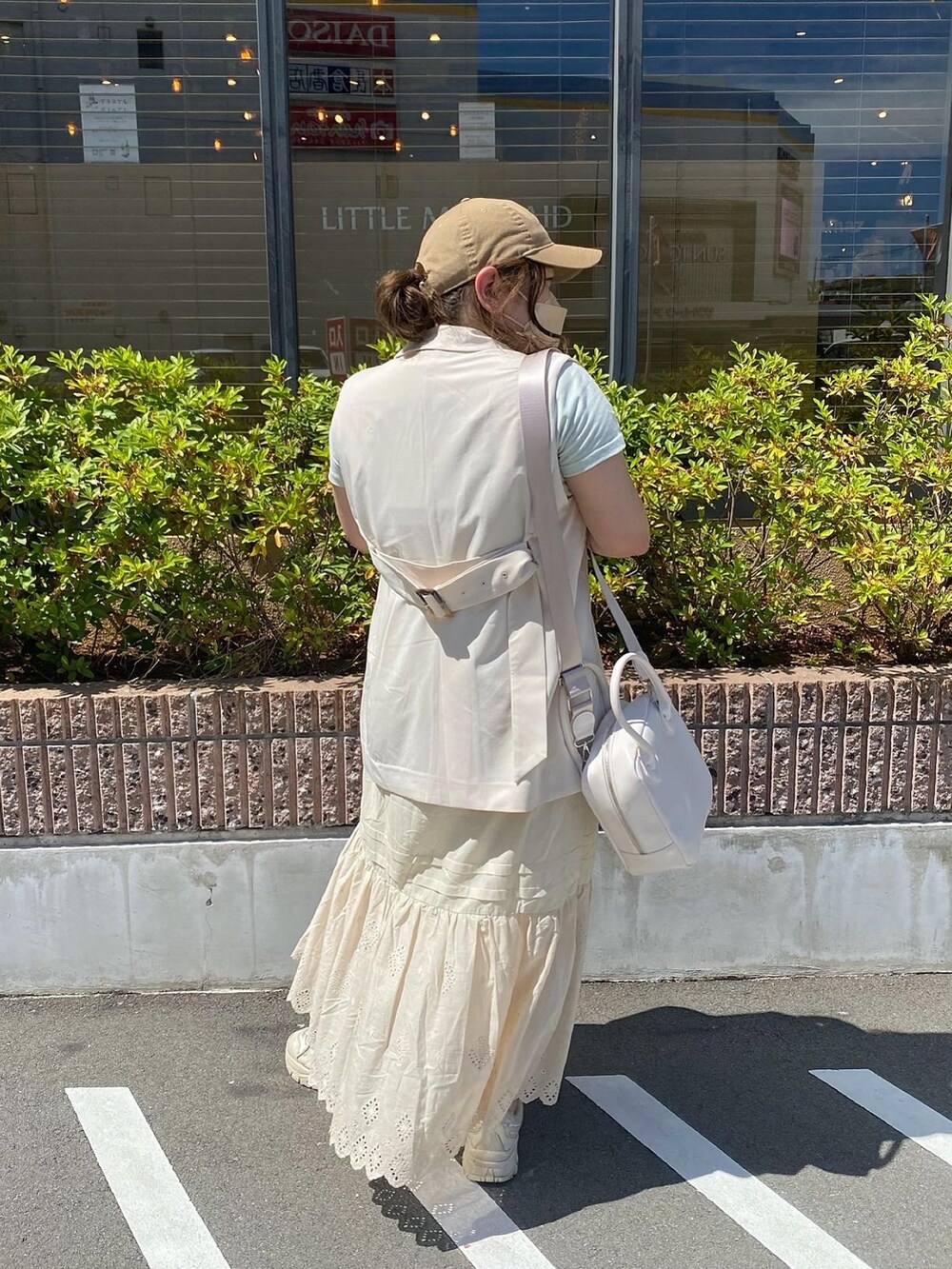 ホワイト系のベスト、グリーン系のTシャツ/カットソー、ベージュ系のスカートを着用したレディースの夏コーディネートの4枚目の写真