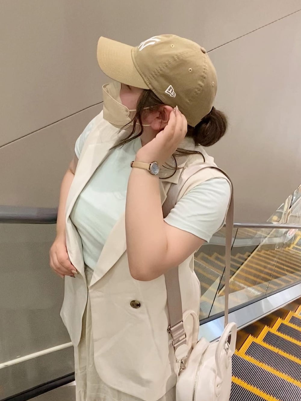 ホワイト系のベスト、グリーン系のTシャツ/カットソー、ベージュ系のスカートを着用したレディースの夏コーディネートの2枚目の写真