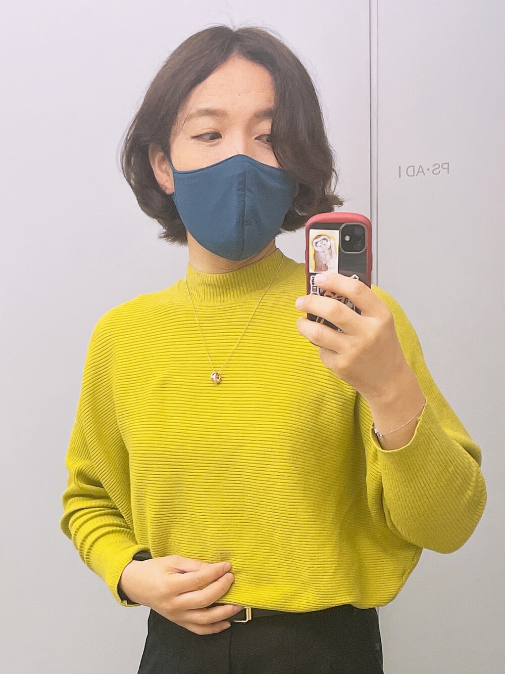 イエロー系のニット/セーター、ブラック系のその他パンツ、シルバー系のブレスレットを着用したレディースの冬コーディネートの2枚目の写真