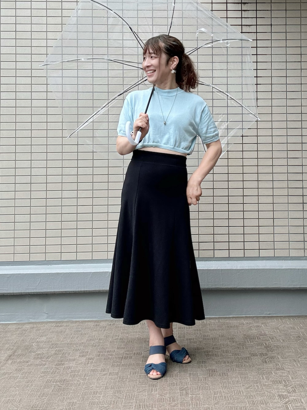 ブルー系のサンダル、レッド系のトートバッグ、ブラック系のスカートを着用したレディースの夏コーディネートの2枚目の写真