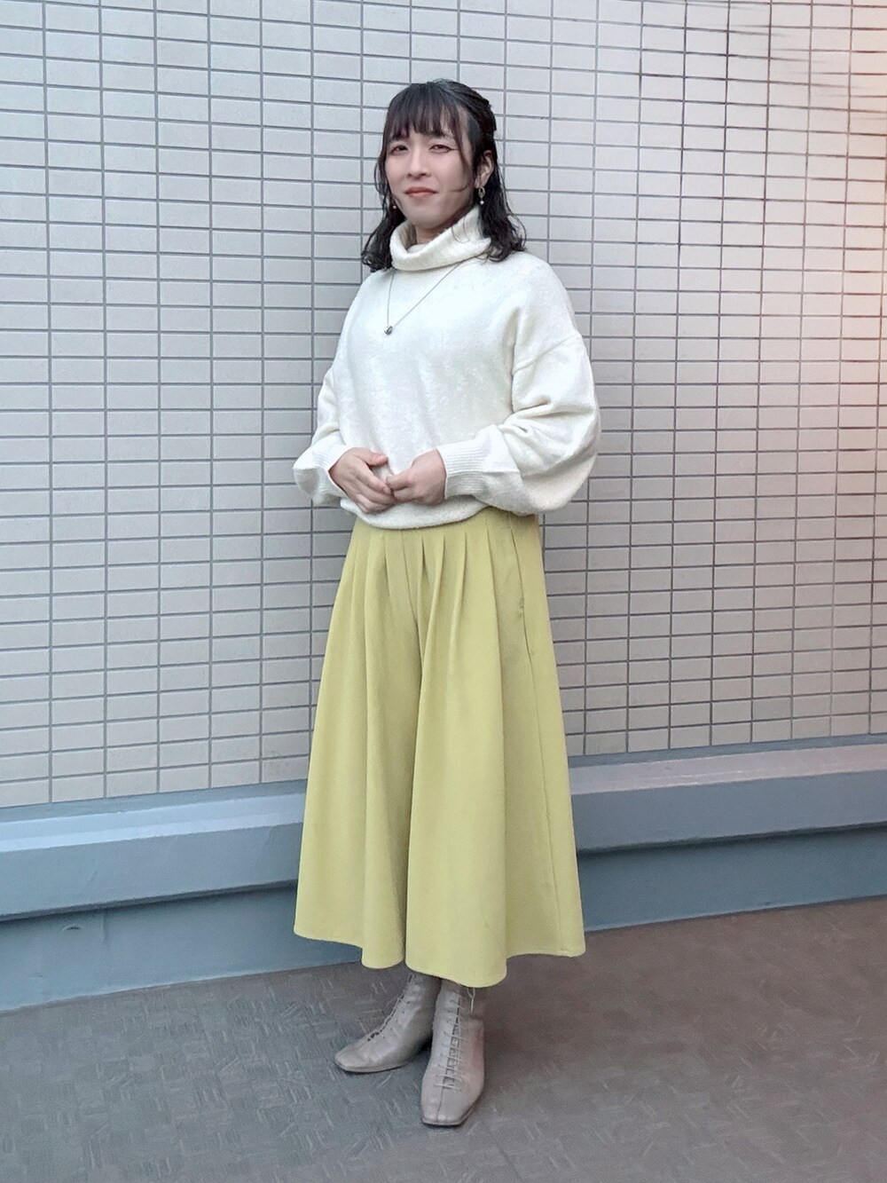 ベージュ系のブーツ、イエロー系のその他パンツ、ホワイト系のその他アウターを着用したレディースの冬コーディネートの3枚目の写真