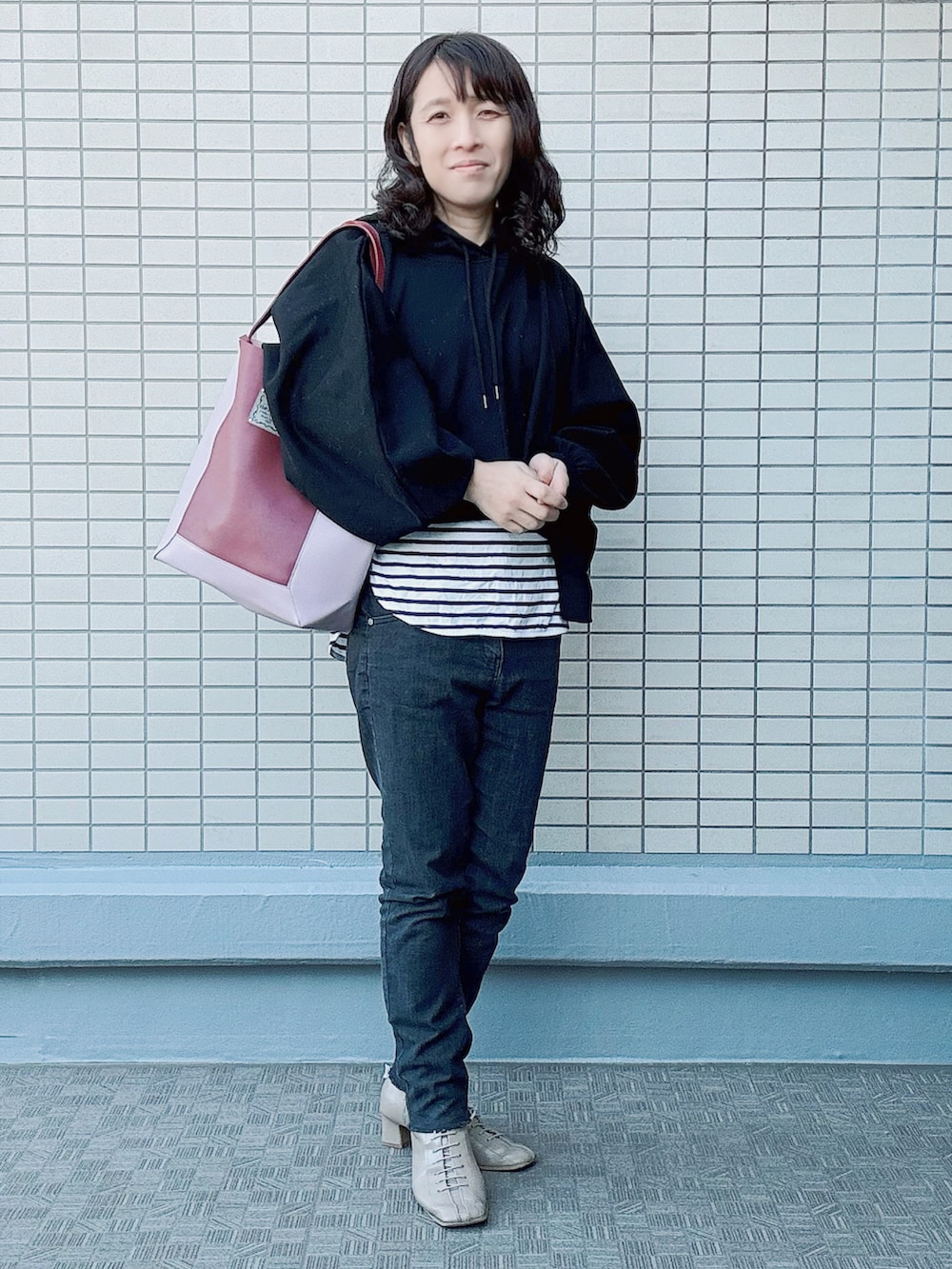 レッド系のトートバッグ、その他のTシャツ/カットソー、ブラック系のトップスを着用したレディースの冬コーディネートの2枚目の写真