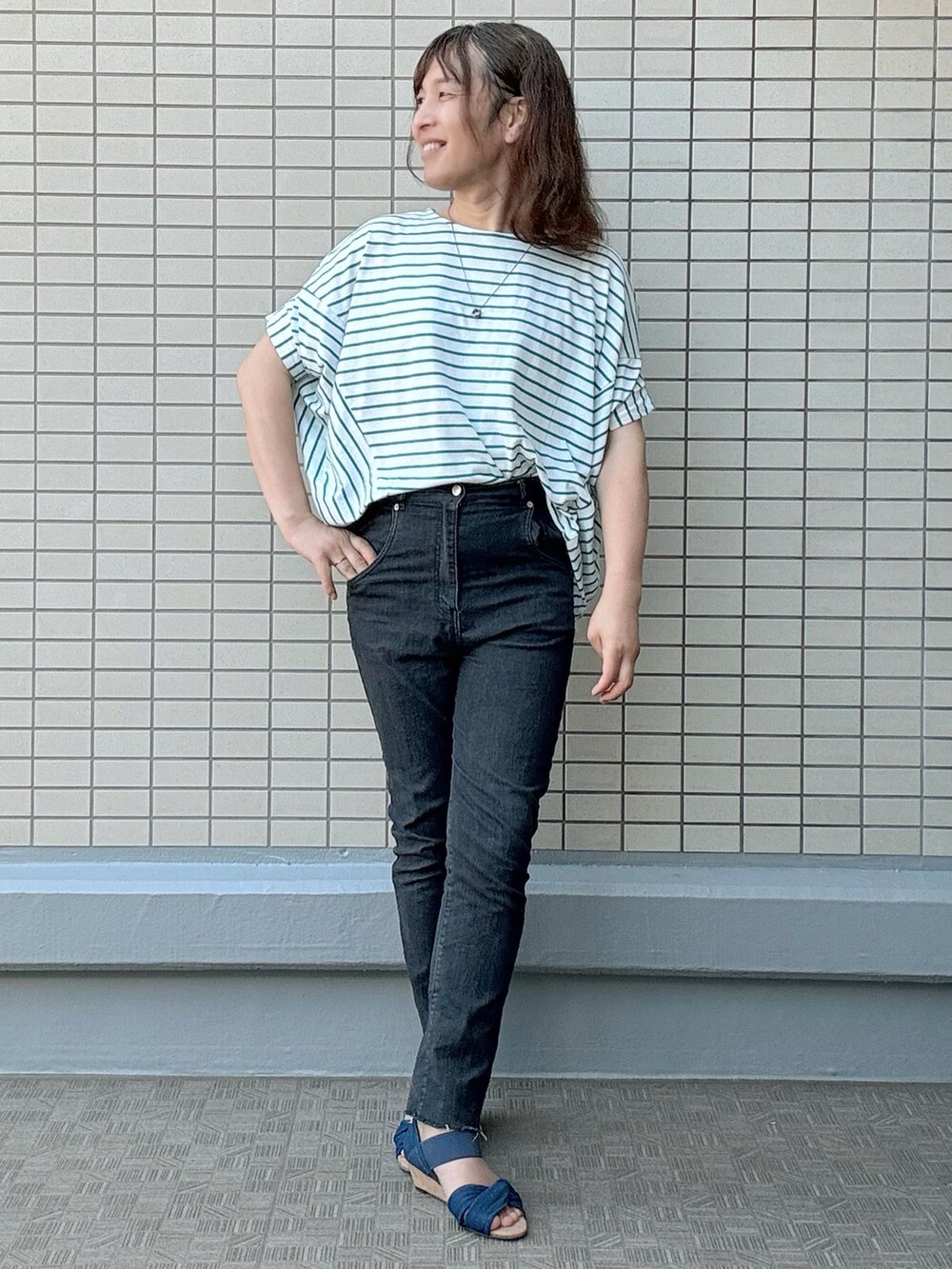 ブルー系のサンダル、ブラック系のデニムパンツ、その他のTシャツ/カットソーを着用したレディースの夏コーディネートの2枚目の写真