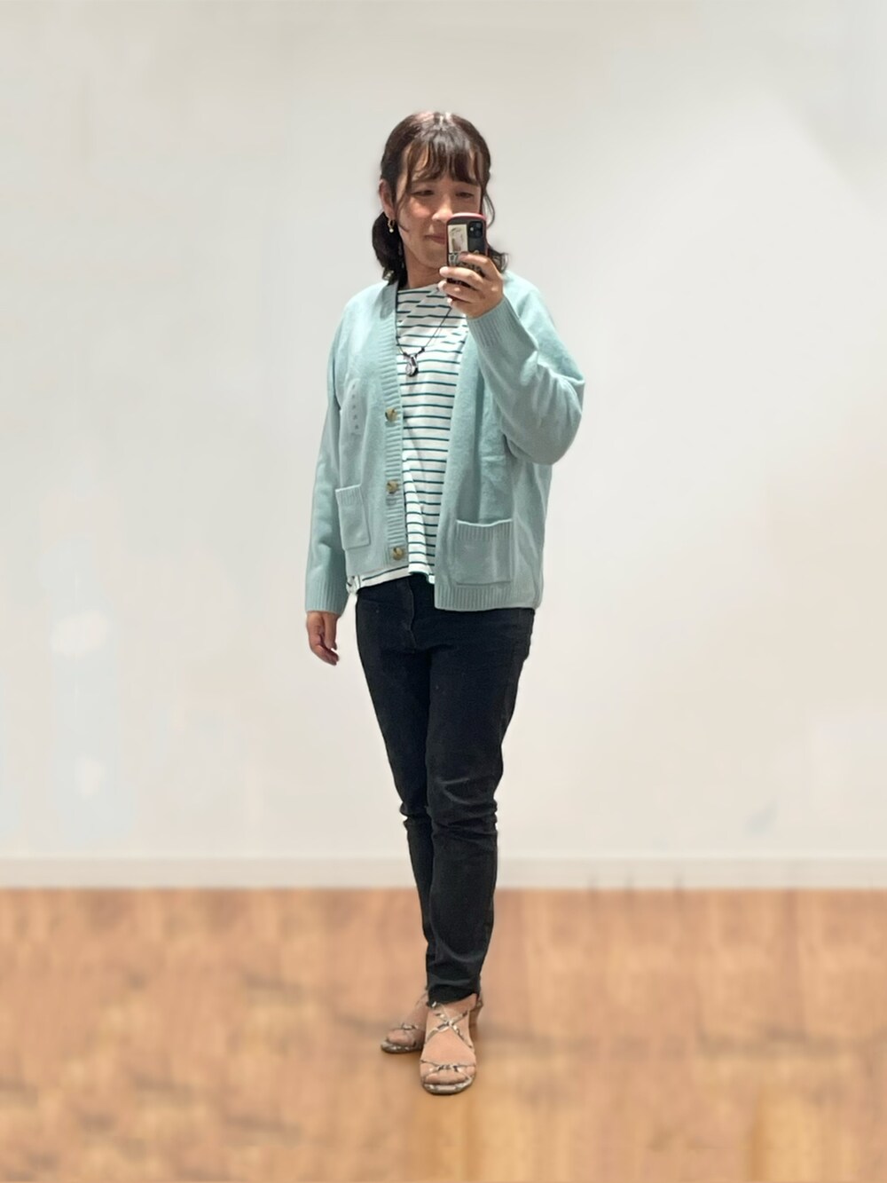 その他のサンダル、ブラック系のデニムパンツ、ブルー系のカーディガン/ボレロを着用したレディースの秋コーディネートの2枚目の写真