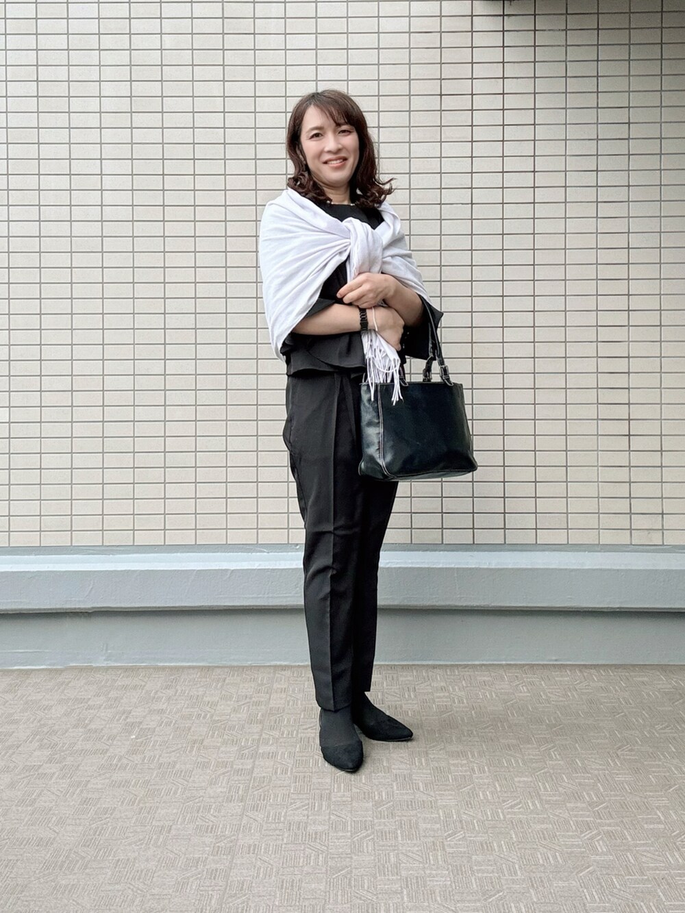 パープル系のスーツパンツ、その他のパンプス、ブラック系のバッグを着用したレディースの春コーディネートの2枚目の写真