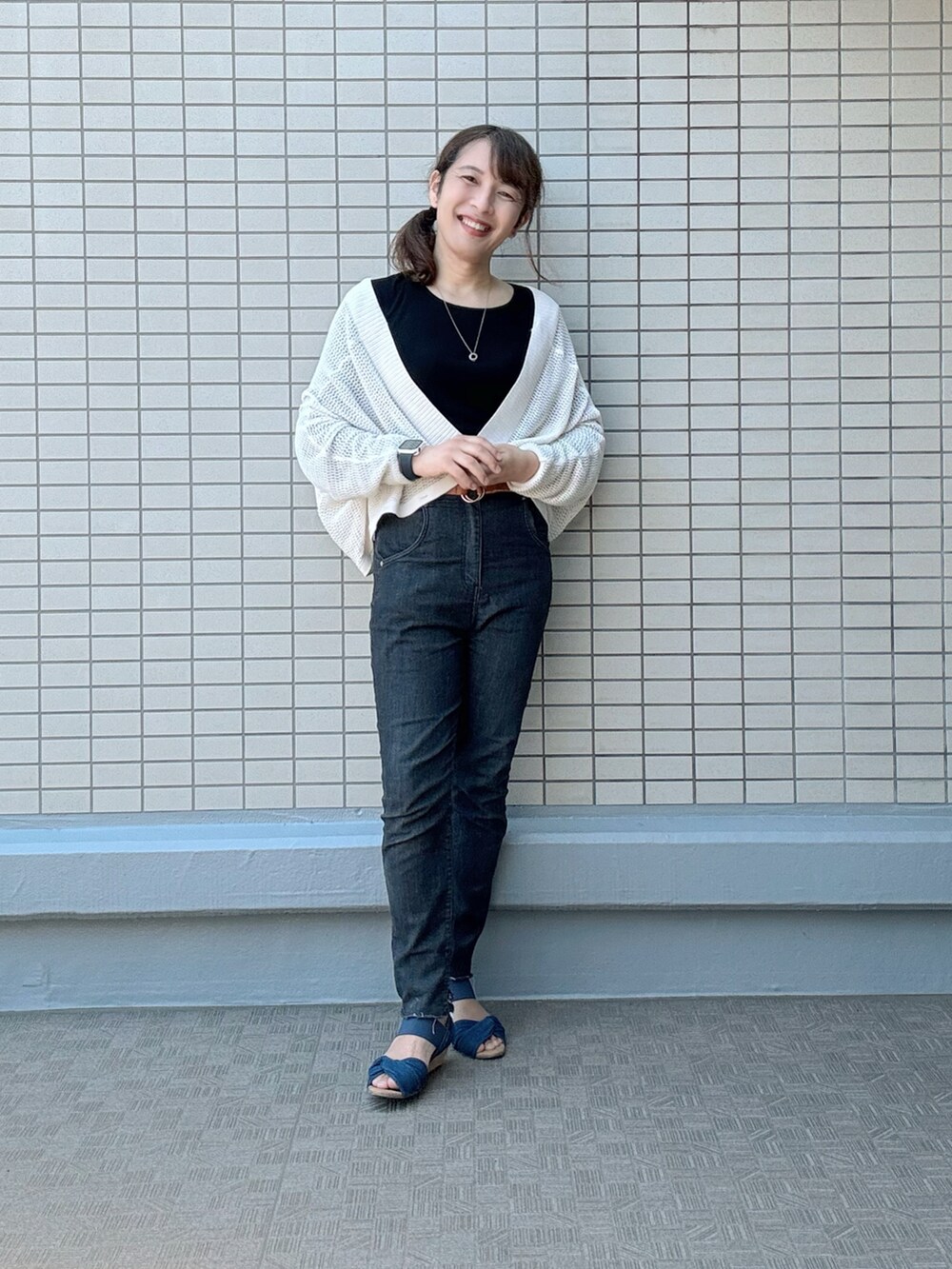 ブルー系のサンダル、ブラック系のデニムパンツ、レッド系のトートバッグを着用したレディースの夏コーディネートの4枚目の写真