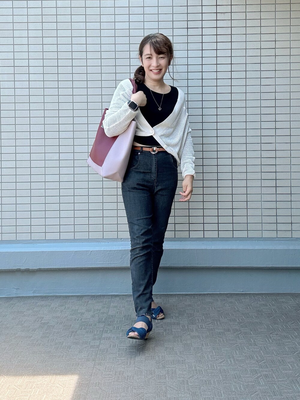 ブルー系のサンダル、ブラック系のデニムパンツ、レッド系のトートバッグを着用したレディースの夏コーディネートの3枚目の写真