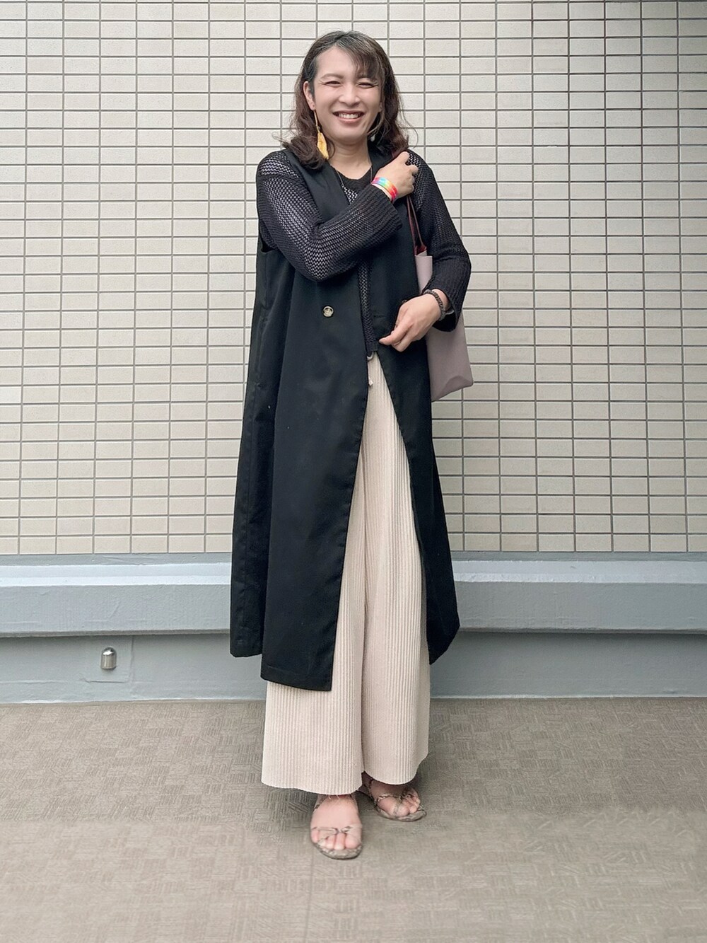 その他のサンダル、レッド系のトートバッグ、ブラック系のトレンチコートを着用したレディースの春コーディネートの4枚目の写真