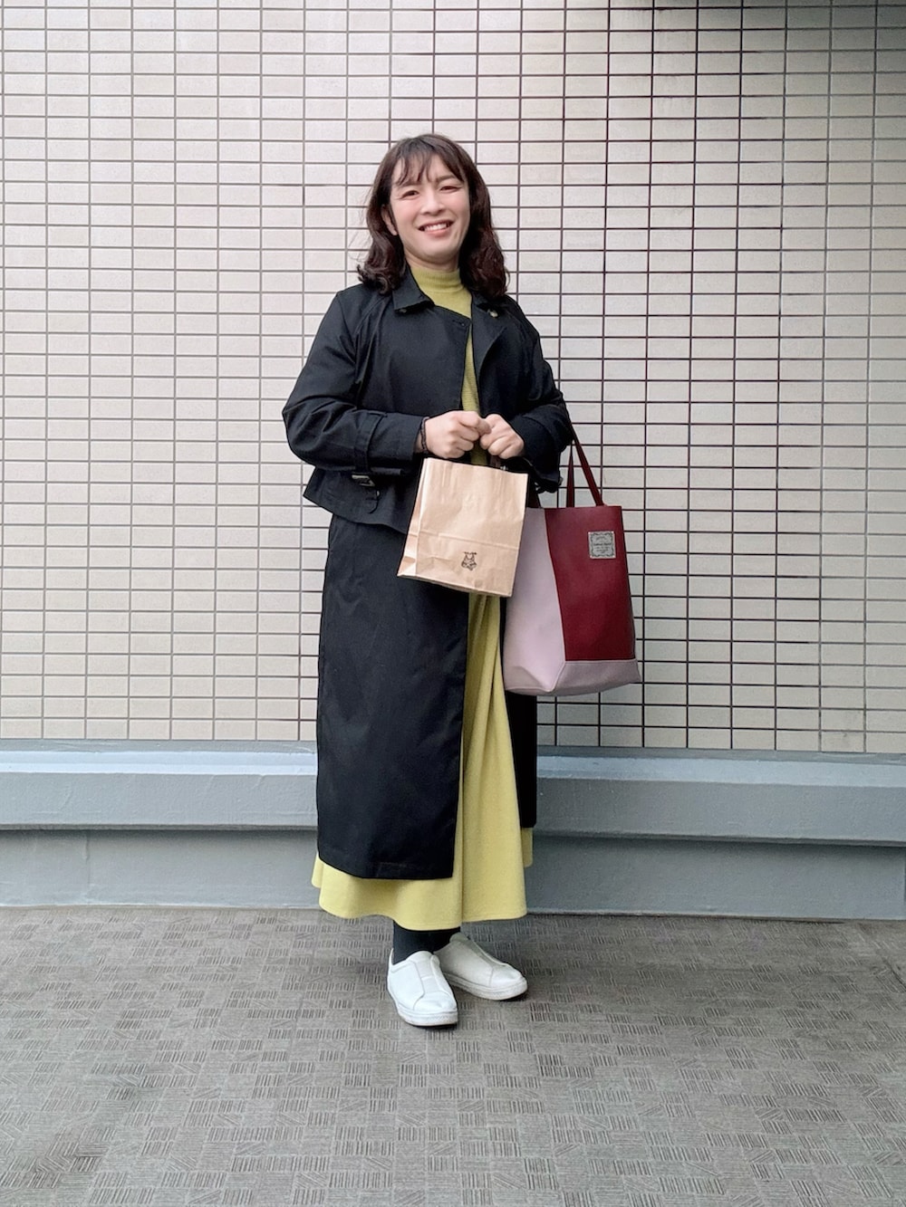 ホワイト系のスニーカー、レッド系のトートバッグ、イエロー系のその他パンツを着用したレディースの冬コーディネートの2枚目の写真