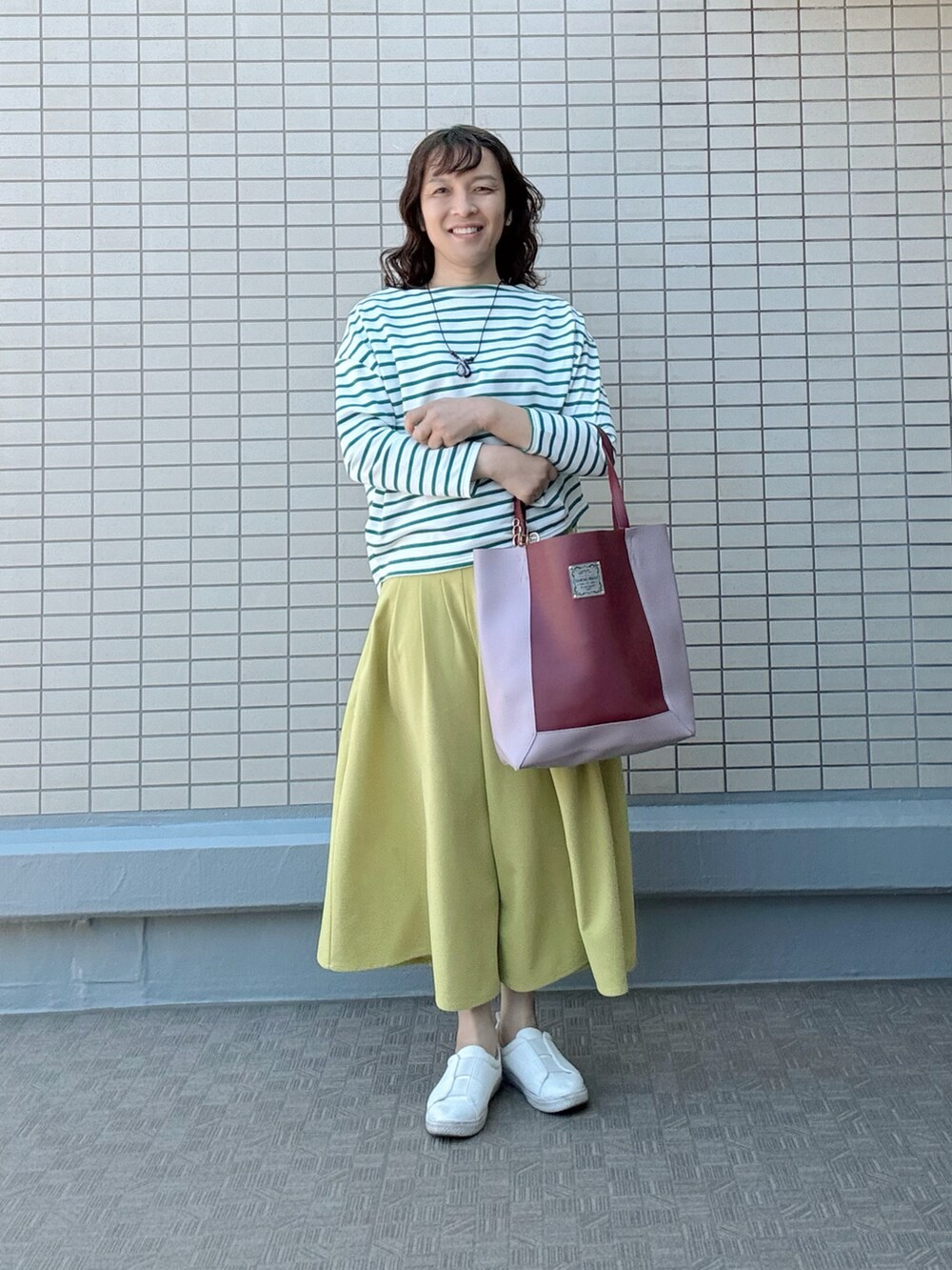 ホワイト系のスニーカー、イエロー系のその他パンツ、レッド系のトートバッグを着用したレディースの春コーディネートの2枚目の写真