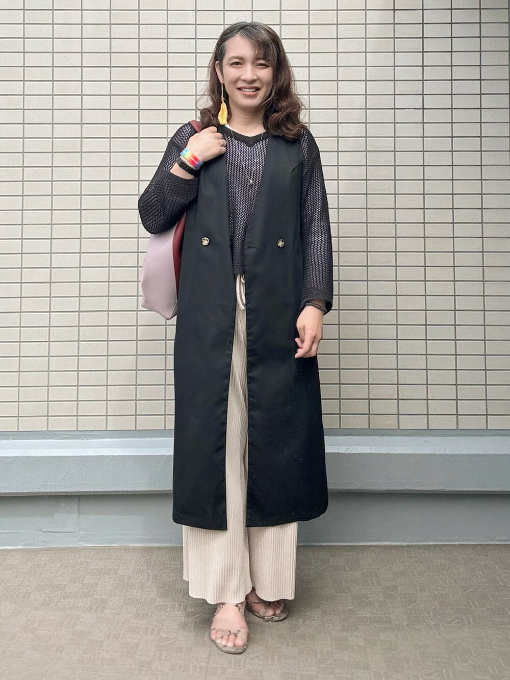 その他のサンダル、レッド系のトートバッグ、ブラック系のトレンチコートを着用したレディースの春コーディネートの3枚目の写真