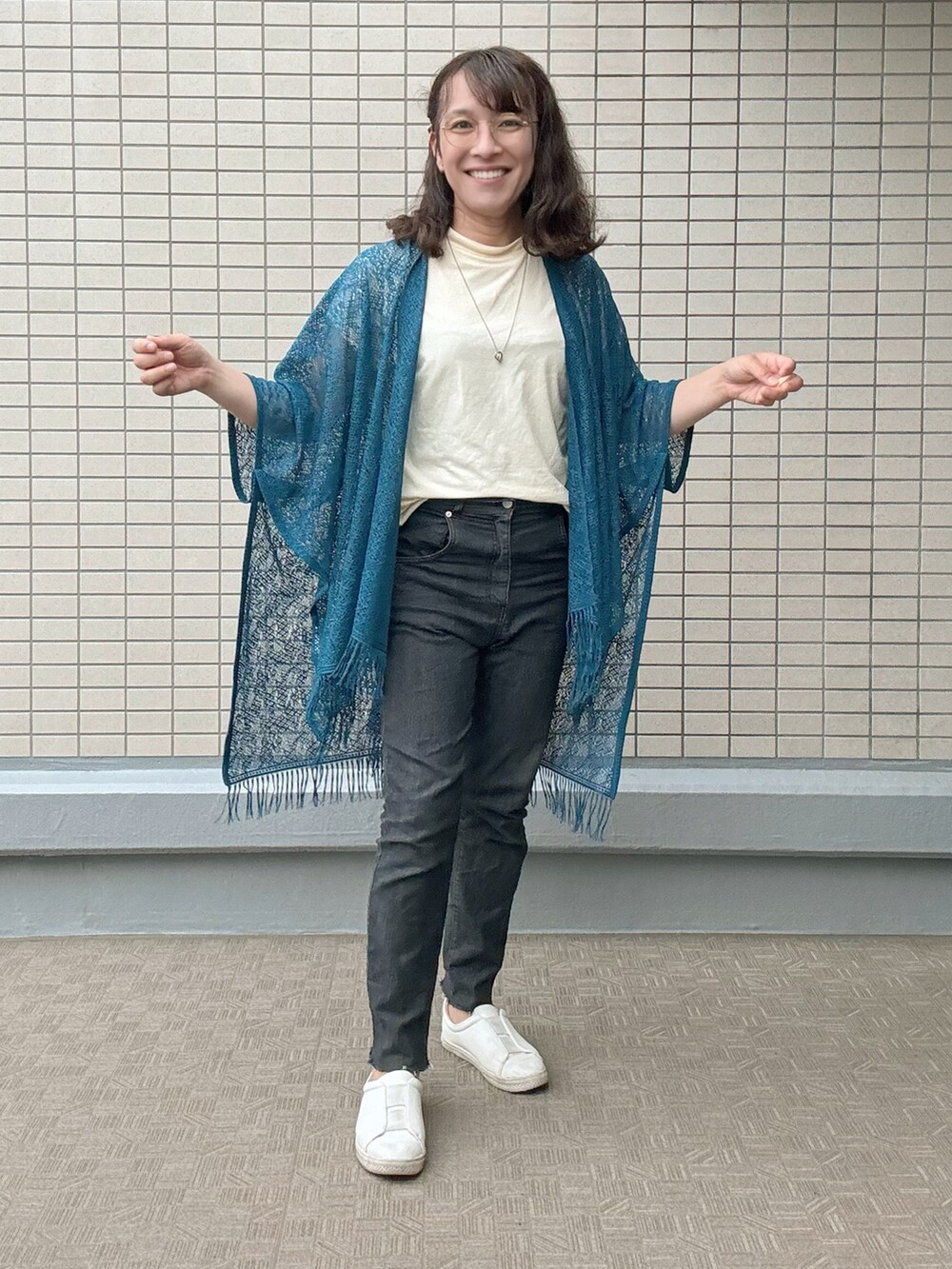 ホワイト系のスニーカー、ブラック系のデニムパンツ、レッド系のトートバッグを着用したレディースの春コーディネートの3枚目の写真