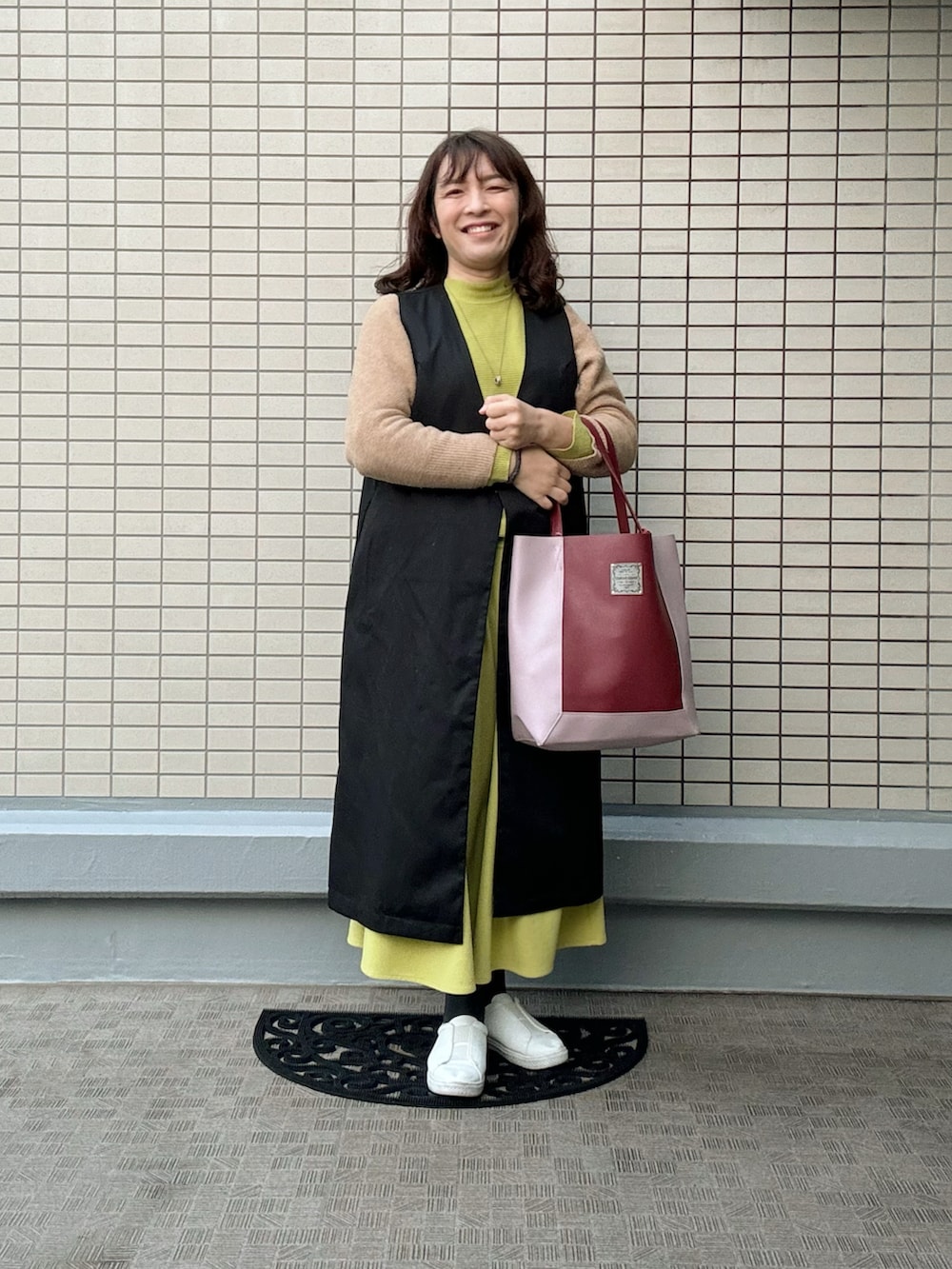 ホワイト系のスニーカー、レッド系のトートバッグ、イエロー系のその他パンツを着用したレディースの冬コーディネートの3枚目の写真