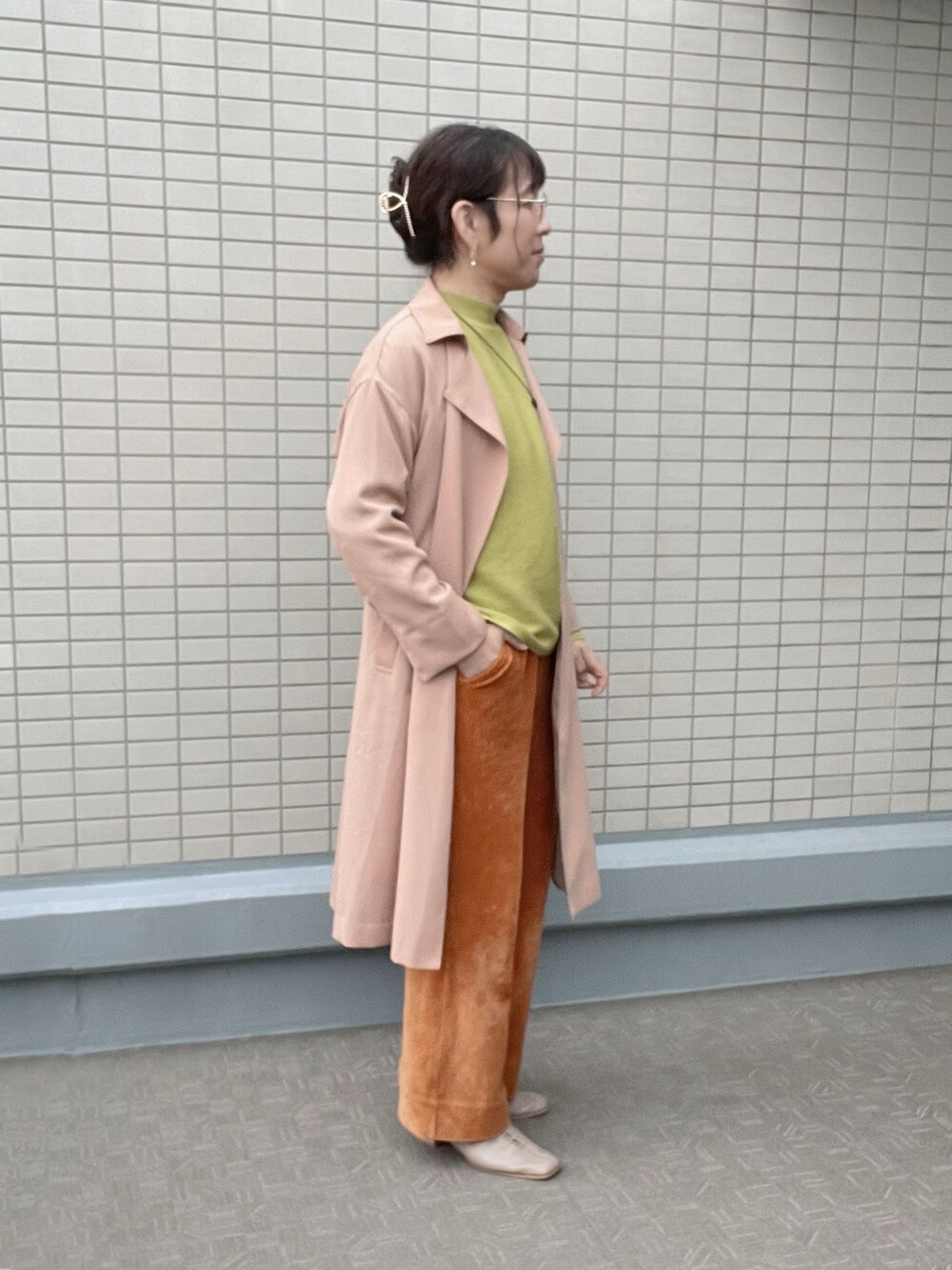 ベージュ系のその他アウター、イエロー系のニット/セーター、ブラウン系のパンツを着用したレディースの冬コーディネートの2枚目の写真