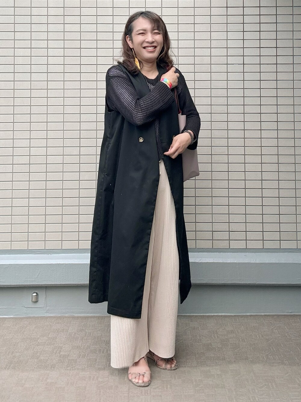 その他のサンダル、レッド系のトートバッグ、ブラック系のトレンチコートを着用したレディースの春コーディネートの5枚目の写真