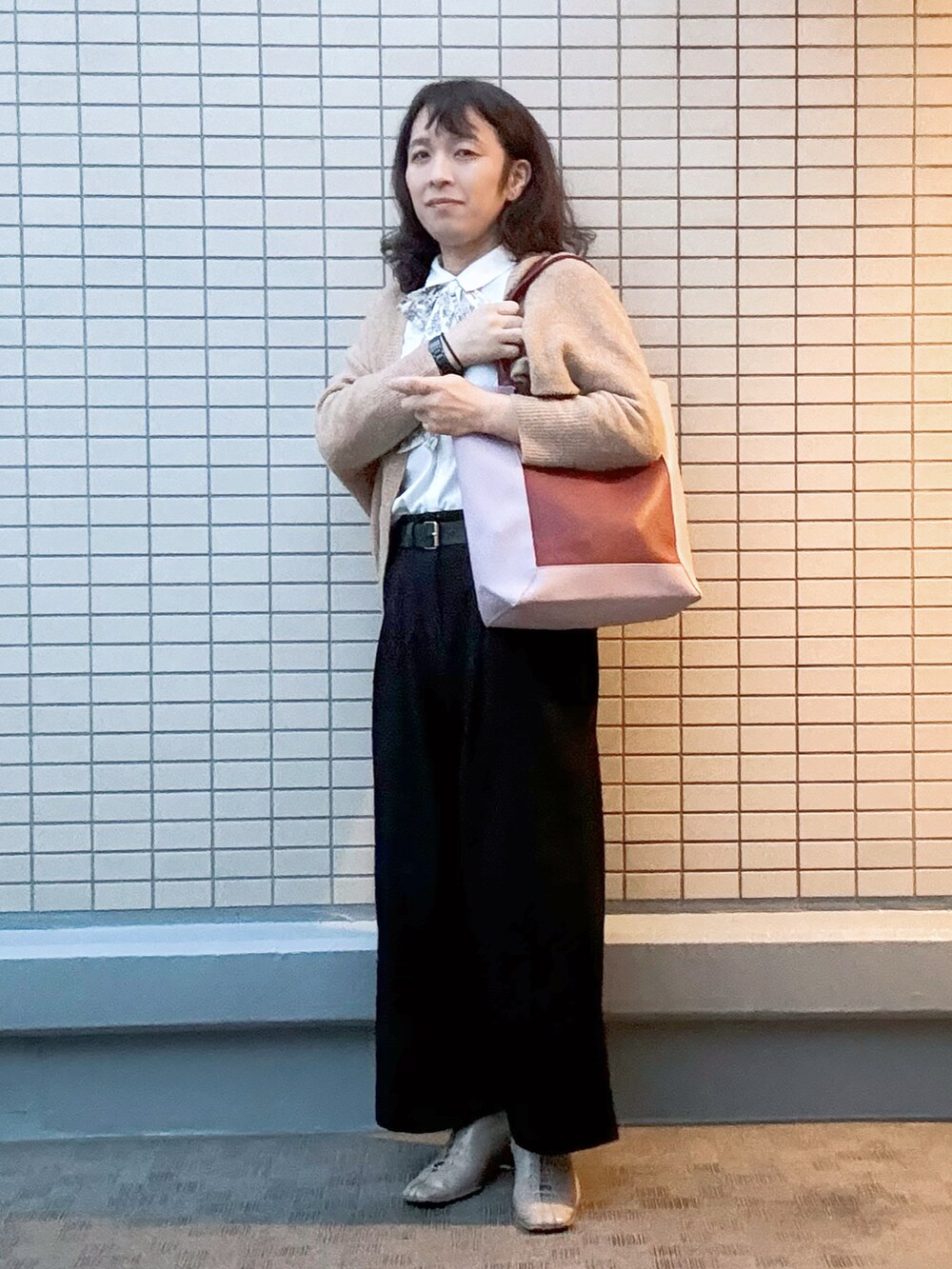 レッド系のトートバッグ、ブラック系のその他パンツ、ベージュ系のブーツを着用したレディースの冬コーディネートの2枚目の写真