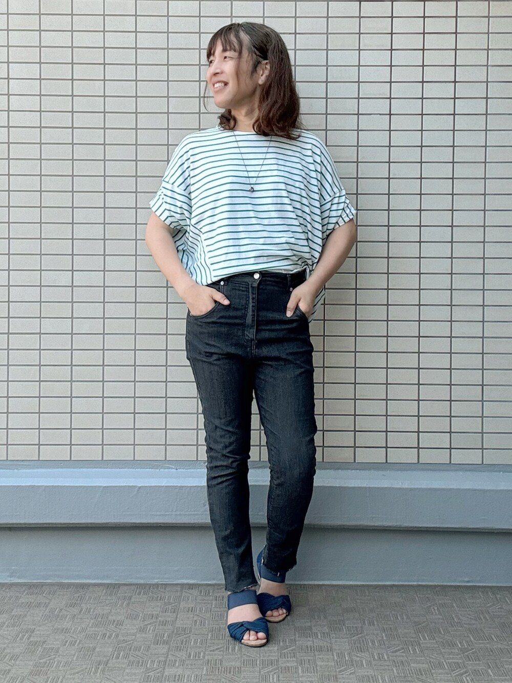 ブルー系のサンダル、ブラック系のデニムパンツ、その他のTシャツ/カットソーを着用したレディースの夏コーディネートの5枚目の写真