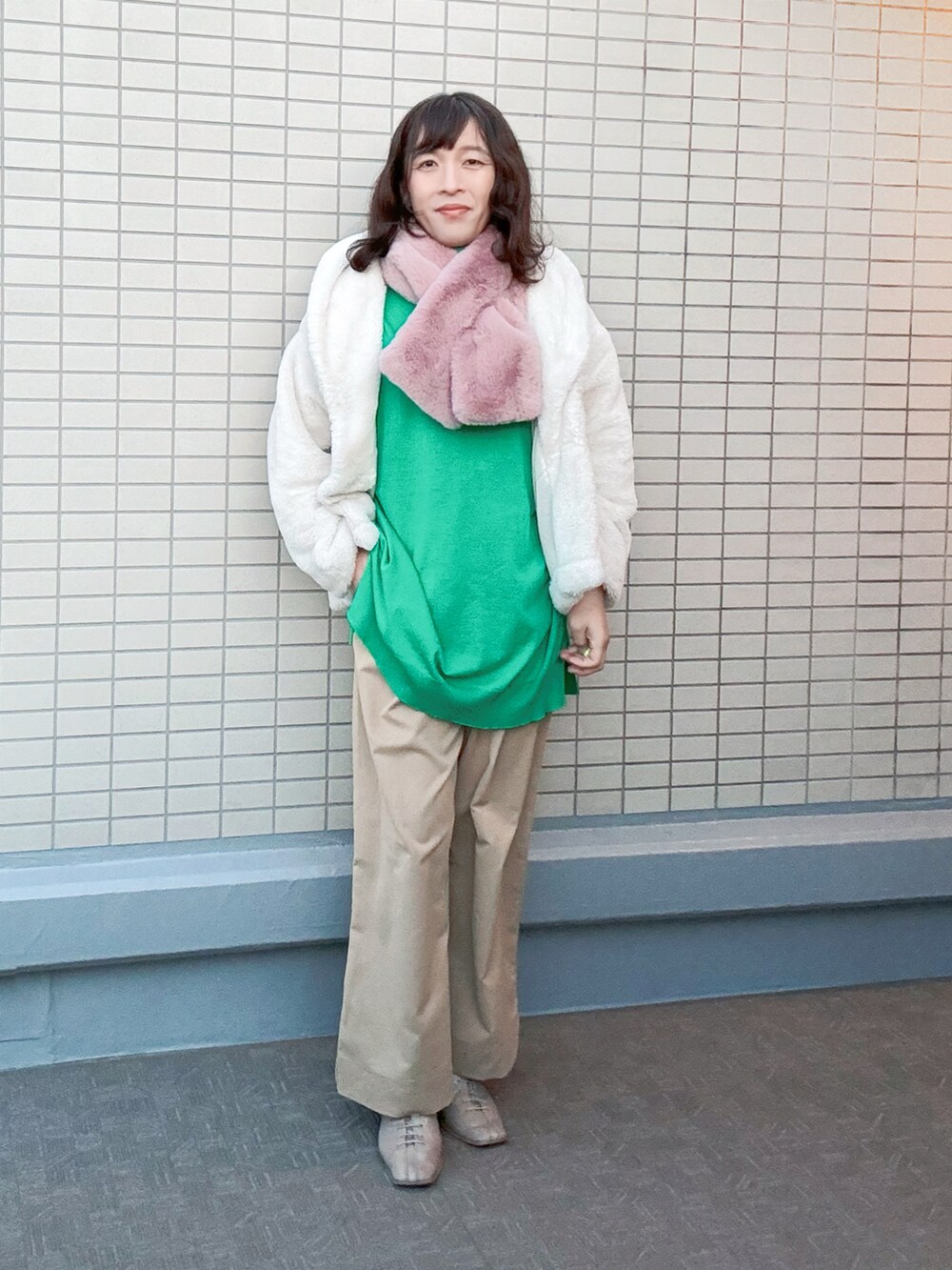 ベージュ系のチノパンツ、ベージュ系のブーツ、グリーン系のニット/セーターを着用したレディースの冬コーディネートの3枚目の写真