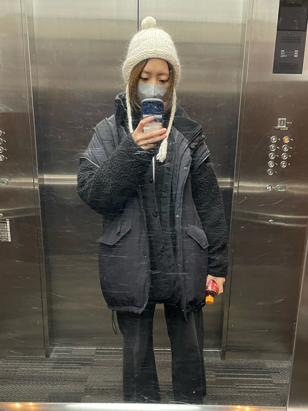 ブラック系のカーディガン/ボレロ、ブラック系のデニムパンツ、ホワイト系のブーツを着用したレディースの冬コーディネートの2枚目の写真