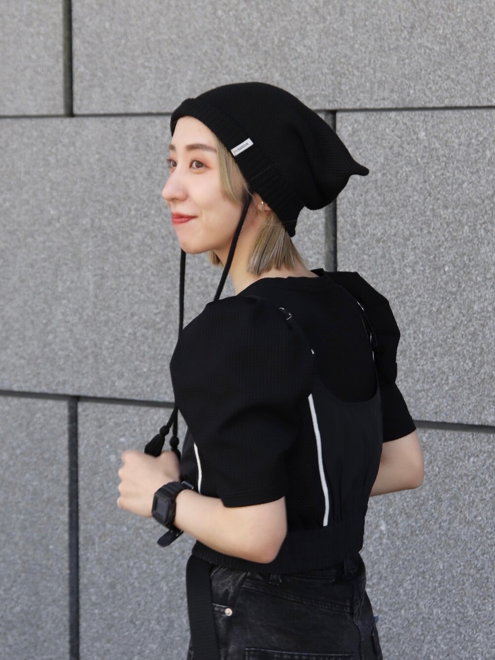 ブラック系のニットキャップ/ビーニーを着用したレディースの冬コーディネートの4枚目の写真